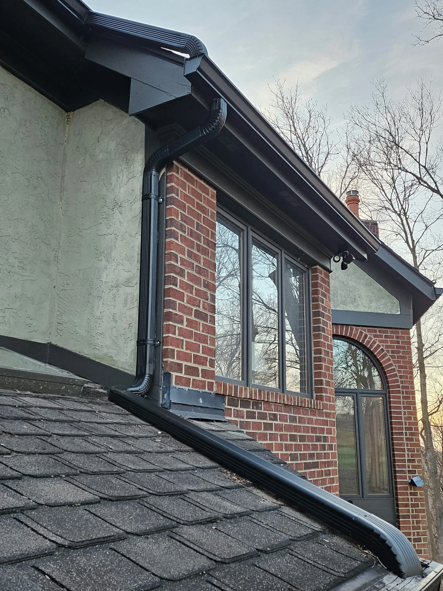 Black seamless gutter installation on Cincinnati home