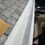 Close-up of restored box gutter alongside repaired slate roof following Bellevue box gutter restoration.